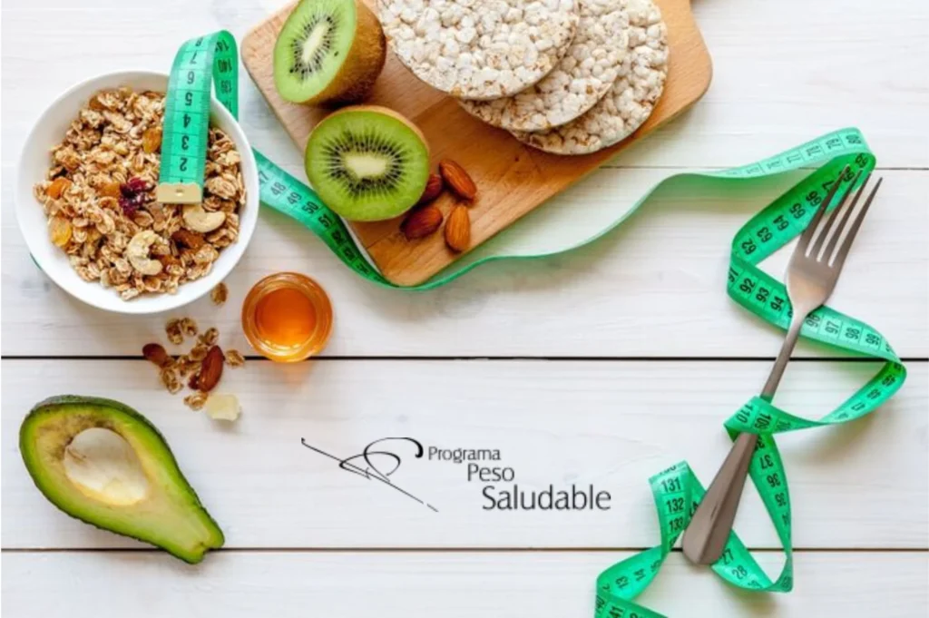 Mesa con alimentos saludables como granola, aguacate, kiwi y miel junto a una cinta métrica verde, símbolo del Programa Peso Saludable y su enfoque clínico en nutrición y control de peso.